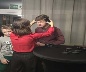 pani zakładająca chłopakowi słuchawki