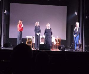 cztery panie stojące na scenie jedna z nich przemawia przez mikrofon