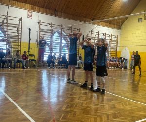 chłopcy stojący pod siatką