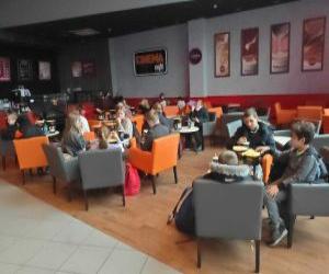 dzieci z Klubu Młodzieżowego przy stolikach w kinie