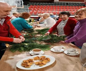 Seniorzy  własnoręcznie wykonujący wieńce świąteczne