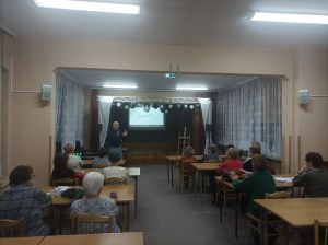 Słuchacze Uniwersytetu Trzeciego Wieku wraz z prowadzącym spotkanie