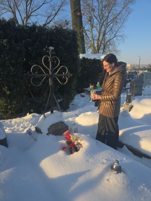 Pani Dominika Piotrowska przy grobie składająca hołd i znicz