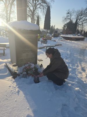 Pani Dominika Piotrowska przy grobie składająca hołd i znicz