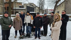obecni mieszkańcy składający znicze pod pomnikiem