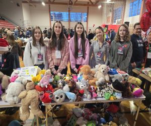 wolontaiusze przy swoim stoisku z maskotkami