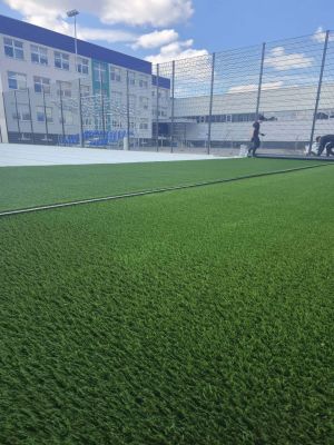 rozkładanie przez pracowników firmy trawę na murawie